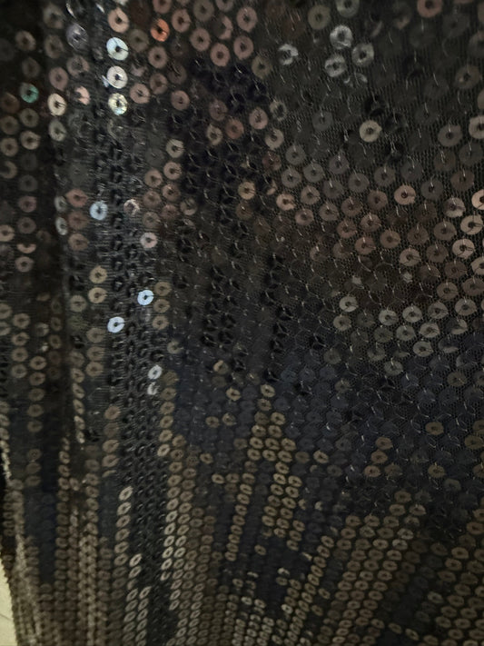 Close-up of the dense, high-quality black sequin embroidery on an elegant women's party dress.