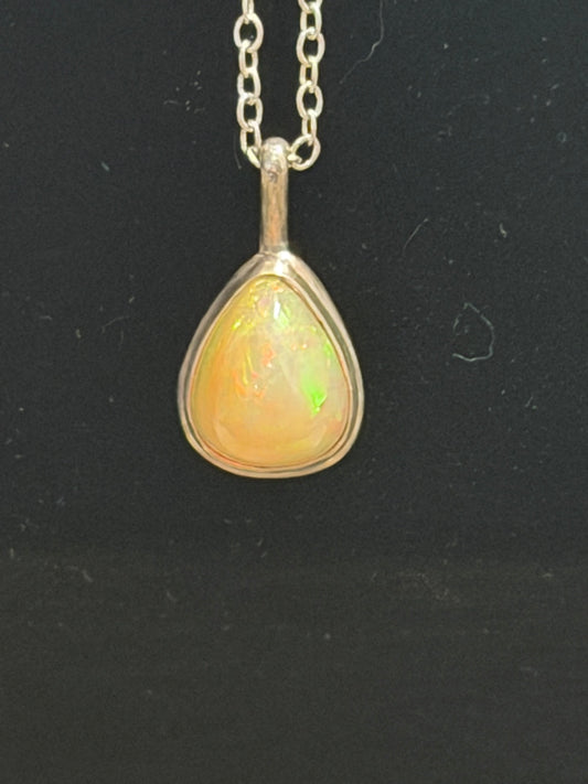 DM9 Ethiopian opal honey teardrop pendant necklace close-up on black