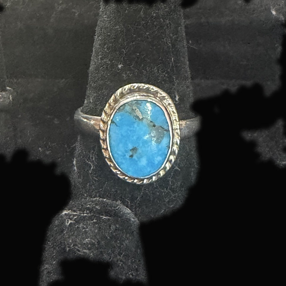 Genuine Turquoise Oval Ring — bright blue oval with dark storm-gray matrix gathering across its crown