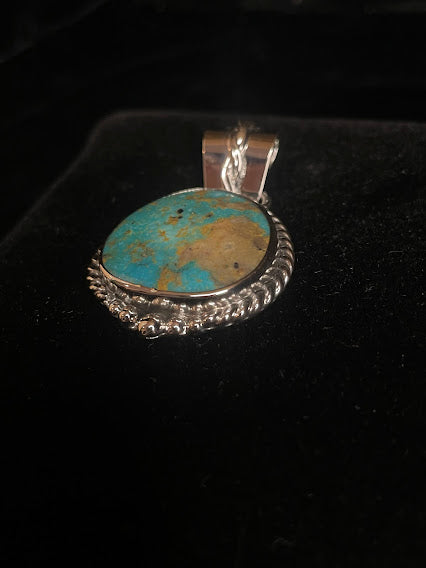Genuine turquoise pendant - angled front view of the blue-green oval stone and its rope bail, stone forward