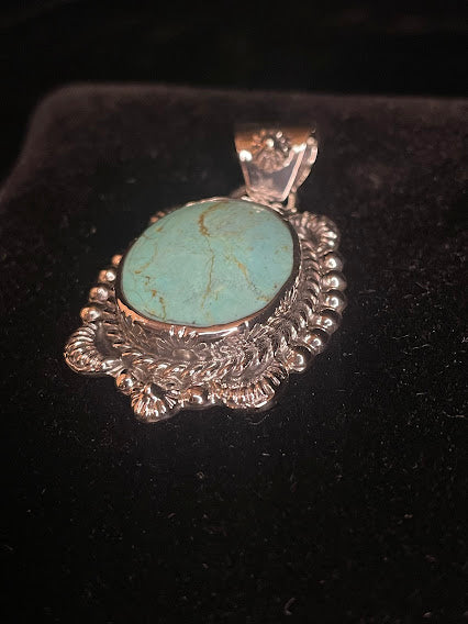 Genuine turquoise pendant - angled front view of the oval stone and its southern star bail, stone face forward