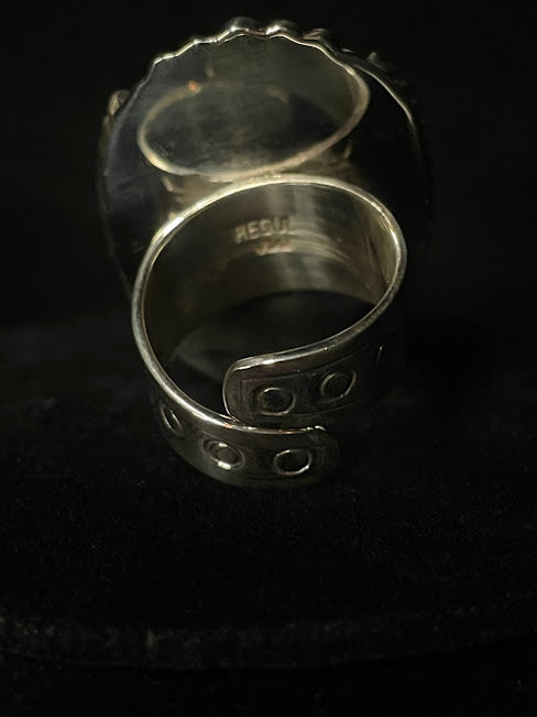 Oval turquoise ring — back view of the split adjustable band, stamped circles at its ends, hallmark inside