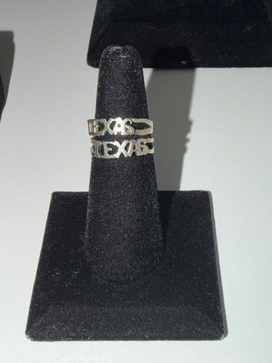 Sterling silver Texas script rings, small and large, on the stand in the Regul Silver case