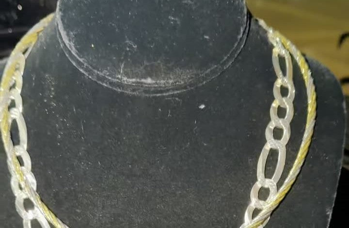 Twisted cable choker necklace in two-tone sterling silver on a black bust, its gold twist running beside a silver figaro
