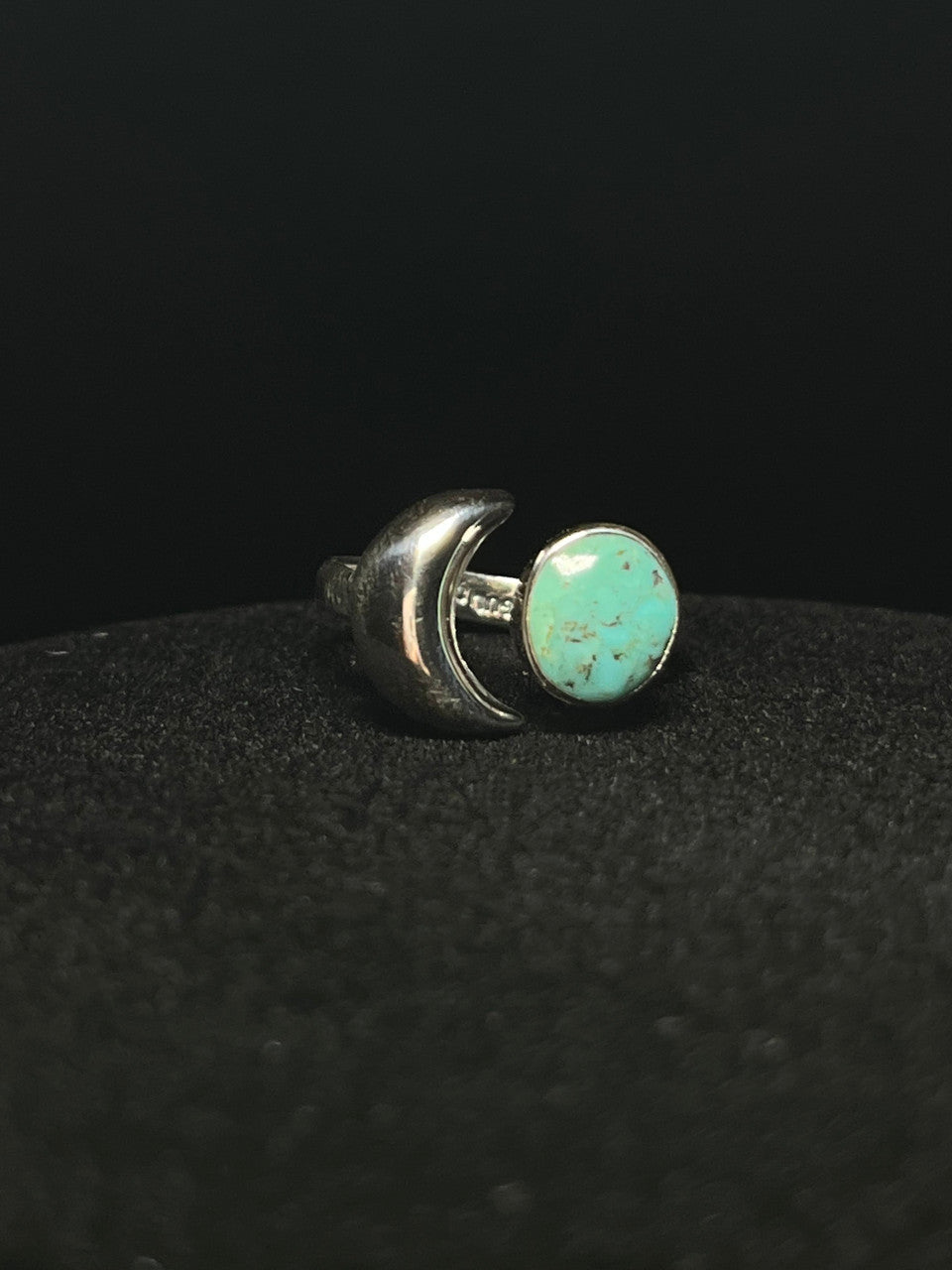 Crescent moon ring — blue-green turquoise oval held in a sterling silver crescent, detail on black