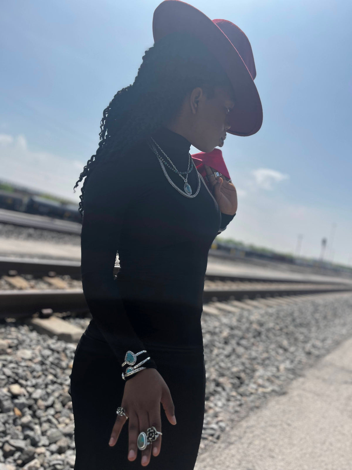 Turquoise cuff bracelet — mini turquoise cuffs worn stacked on a wrist by the railroad tracks, western model view
