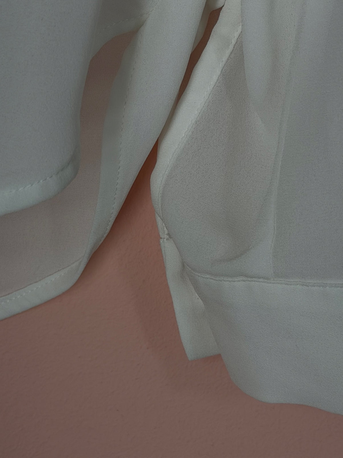 Sleeve cuff and hem detail on the H&M white blouse