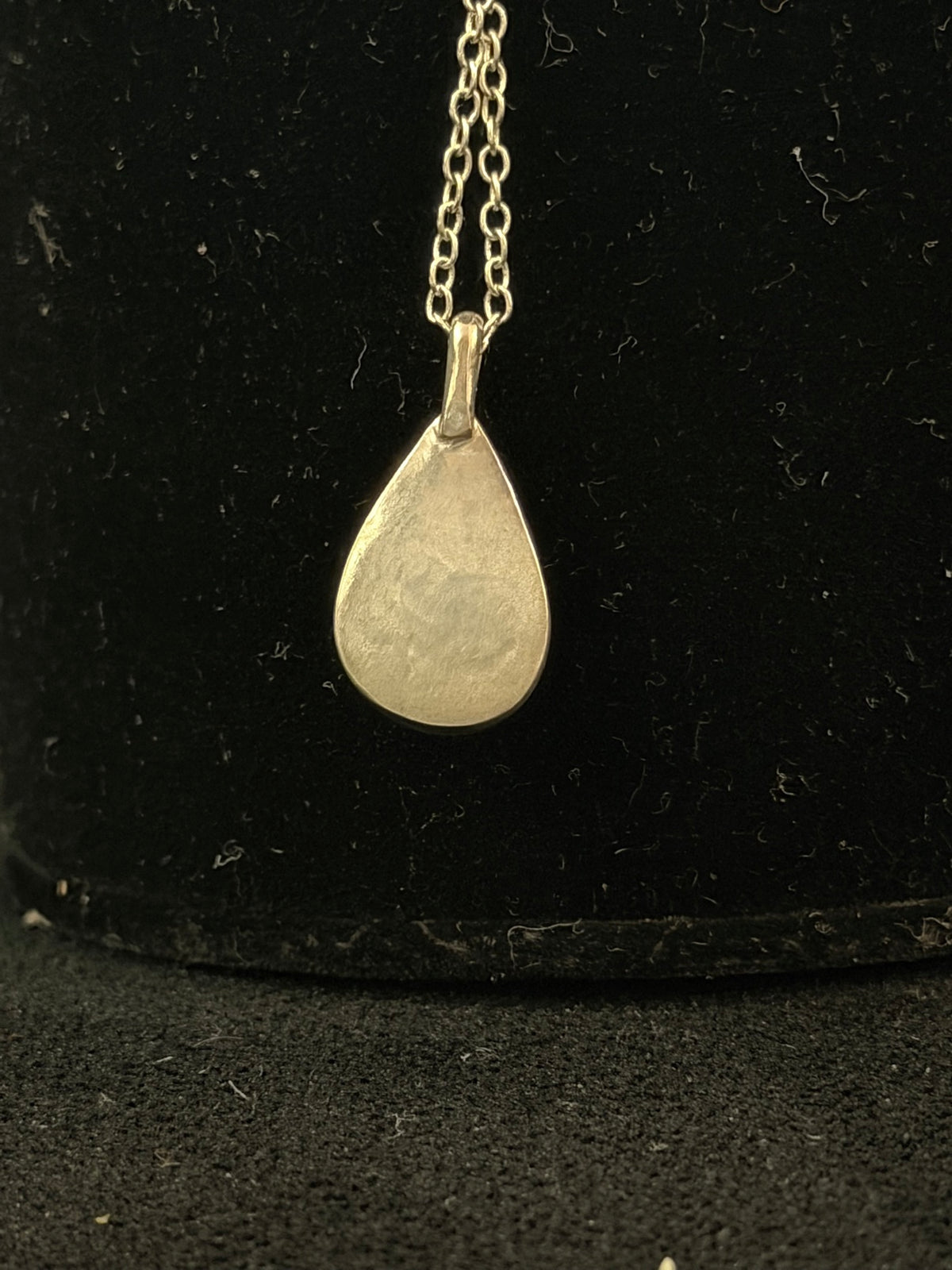 Back of the DM6 Ethiopian opal teardrop pendant showing the solid sterling silver backing