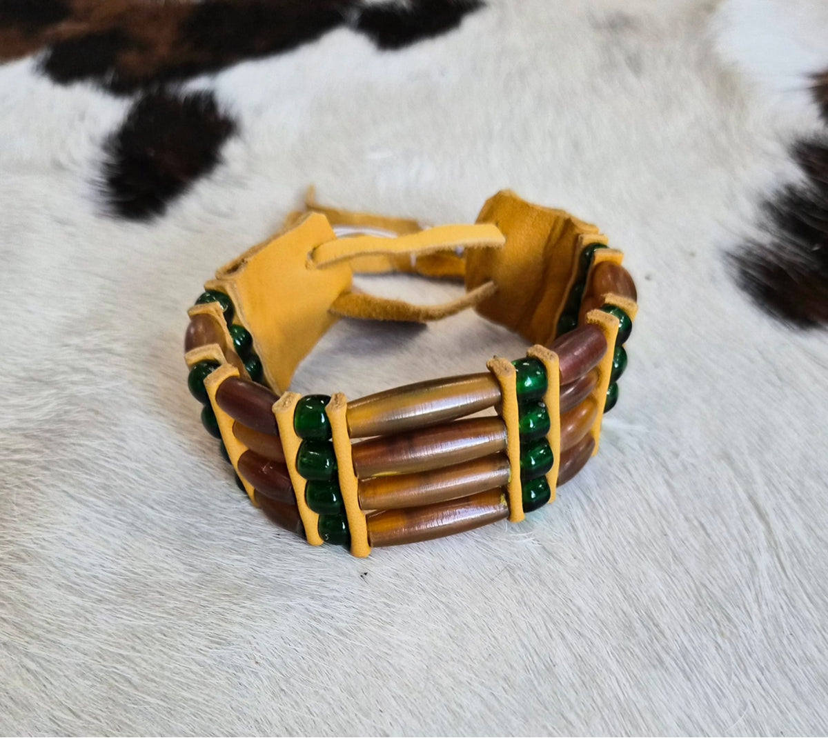 Brown bone hairpipe bracelet with green beads by Southwest by Design on cowhide