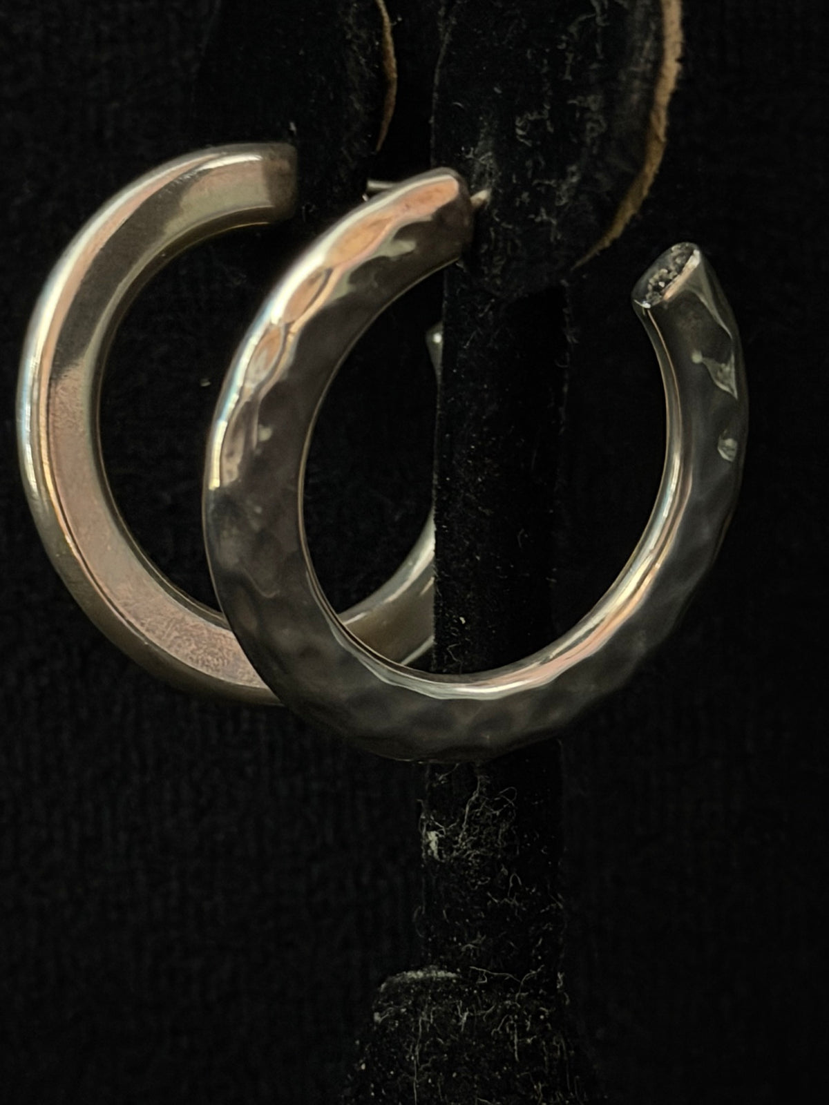 Polished hammered hoop earrings on display stand