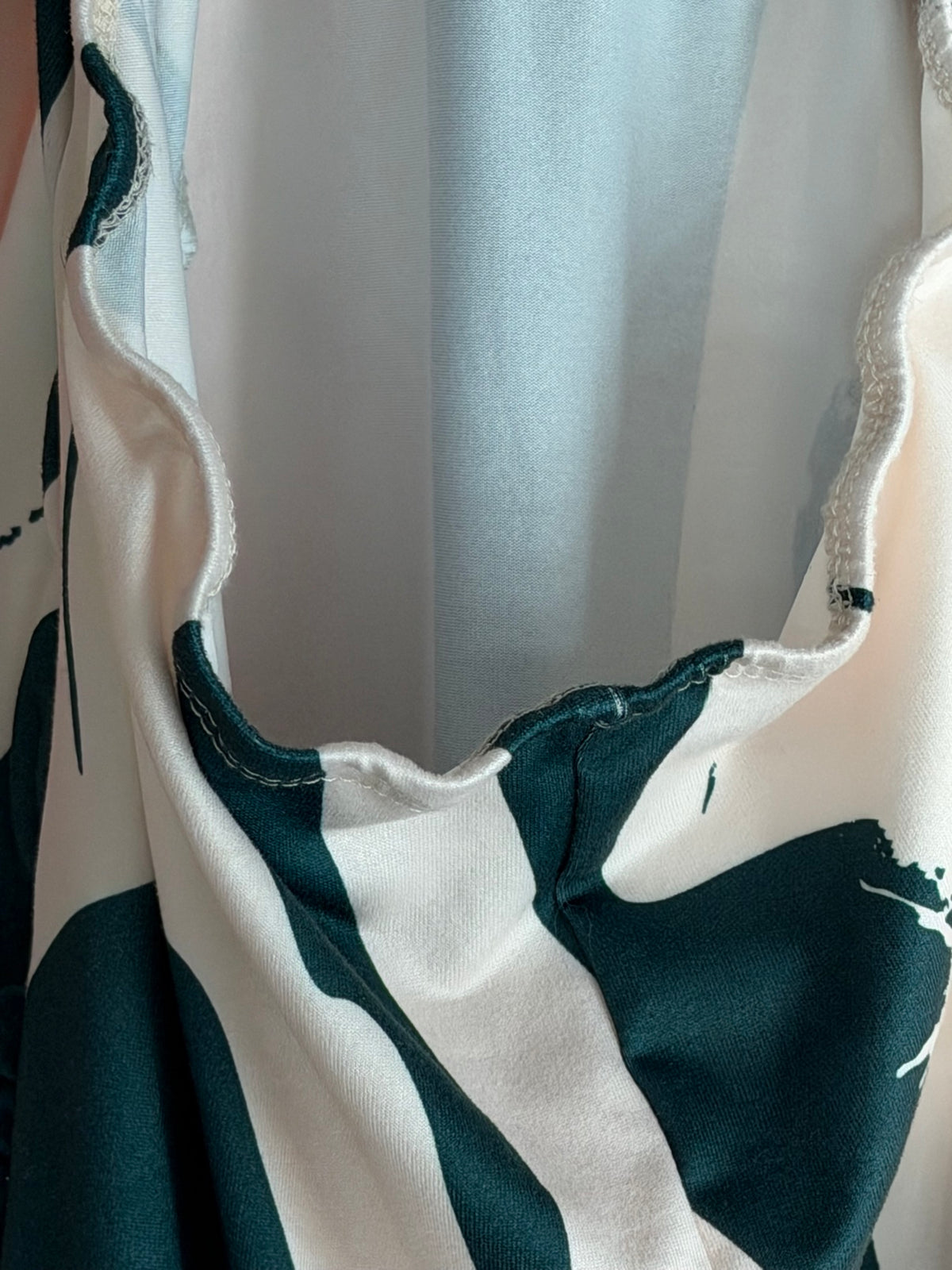 Cream abstract brushstroke halter maxi dress, V-neckline close-up