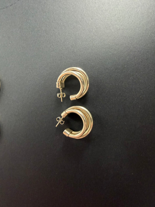 Triple-hoop sterling silver stud earrings on black background