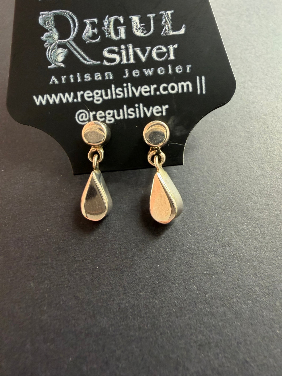 Sterling silver teardrop dangle earrings on black Regul Silver card, full view