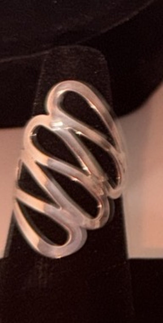 Wide sterling silver zigzag ribbon ring with diagonal waves on a black display cone, size 8