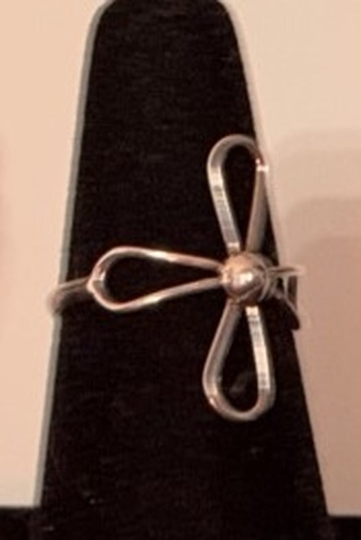 Delicate sterling silver wire flower ring with looped petals and a center bead on a black display cone, size 8