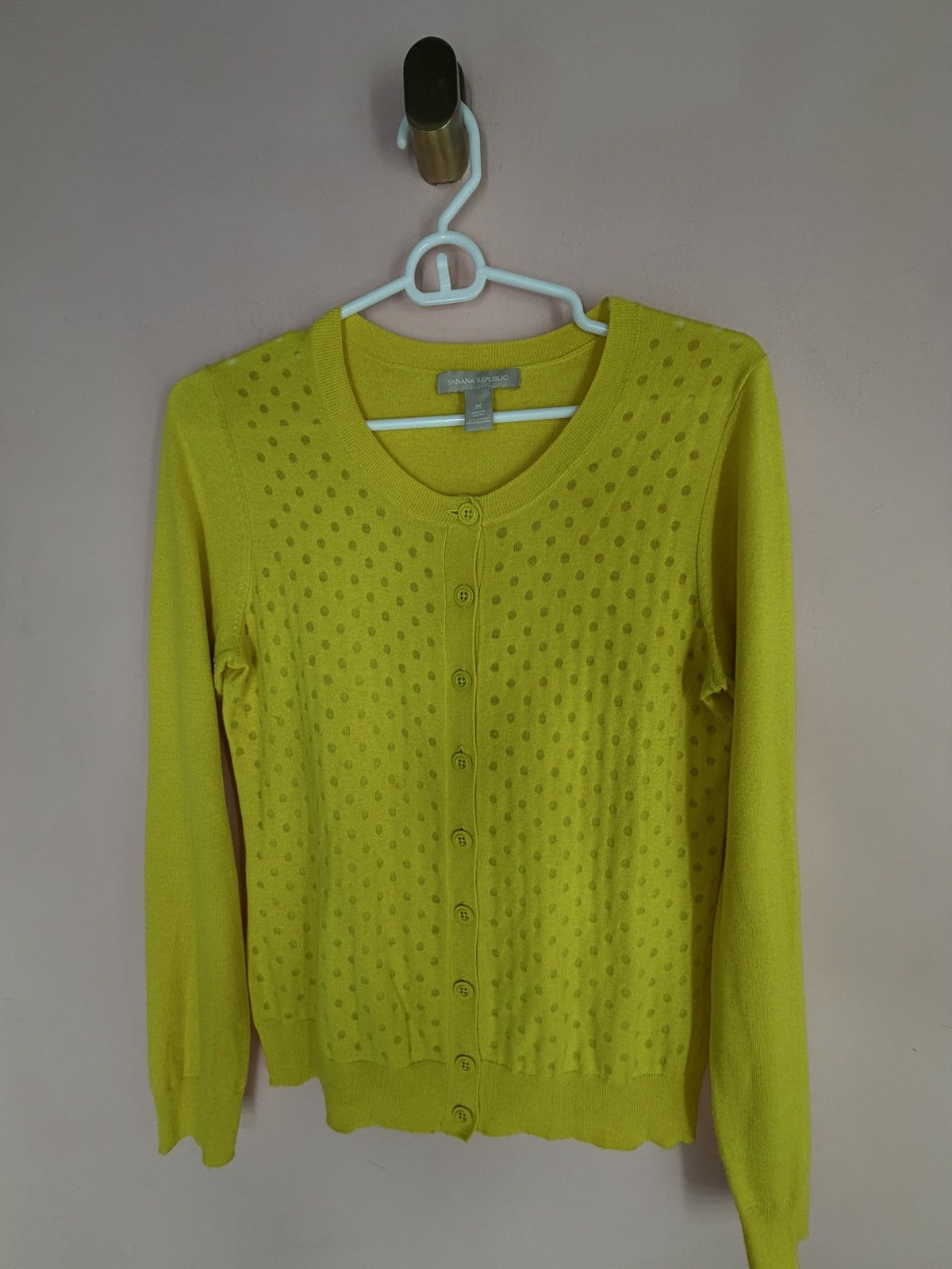 Banana Republic chartreuse polka-dot cardigan, front view on hanger