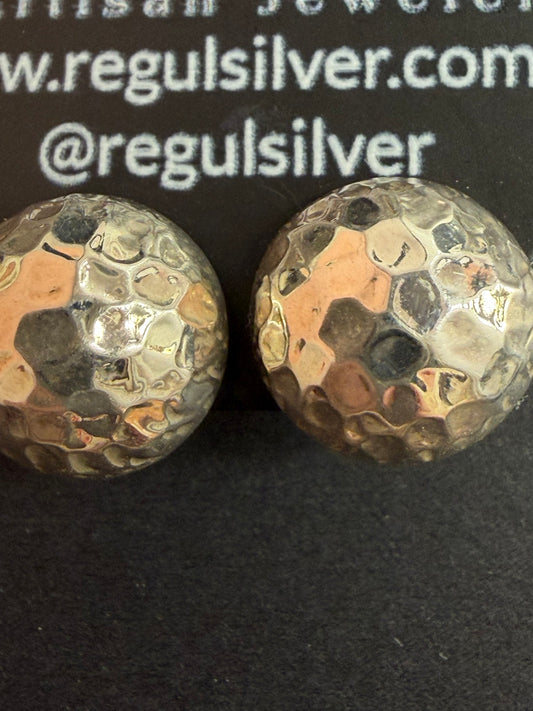 Pair of hammered dome sterling silver studs on black Regul Silver card, close-up