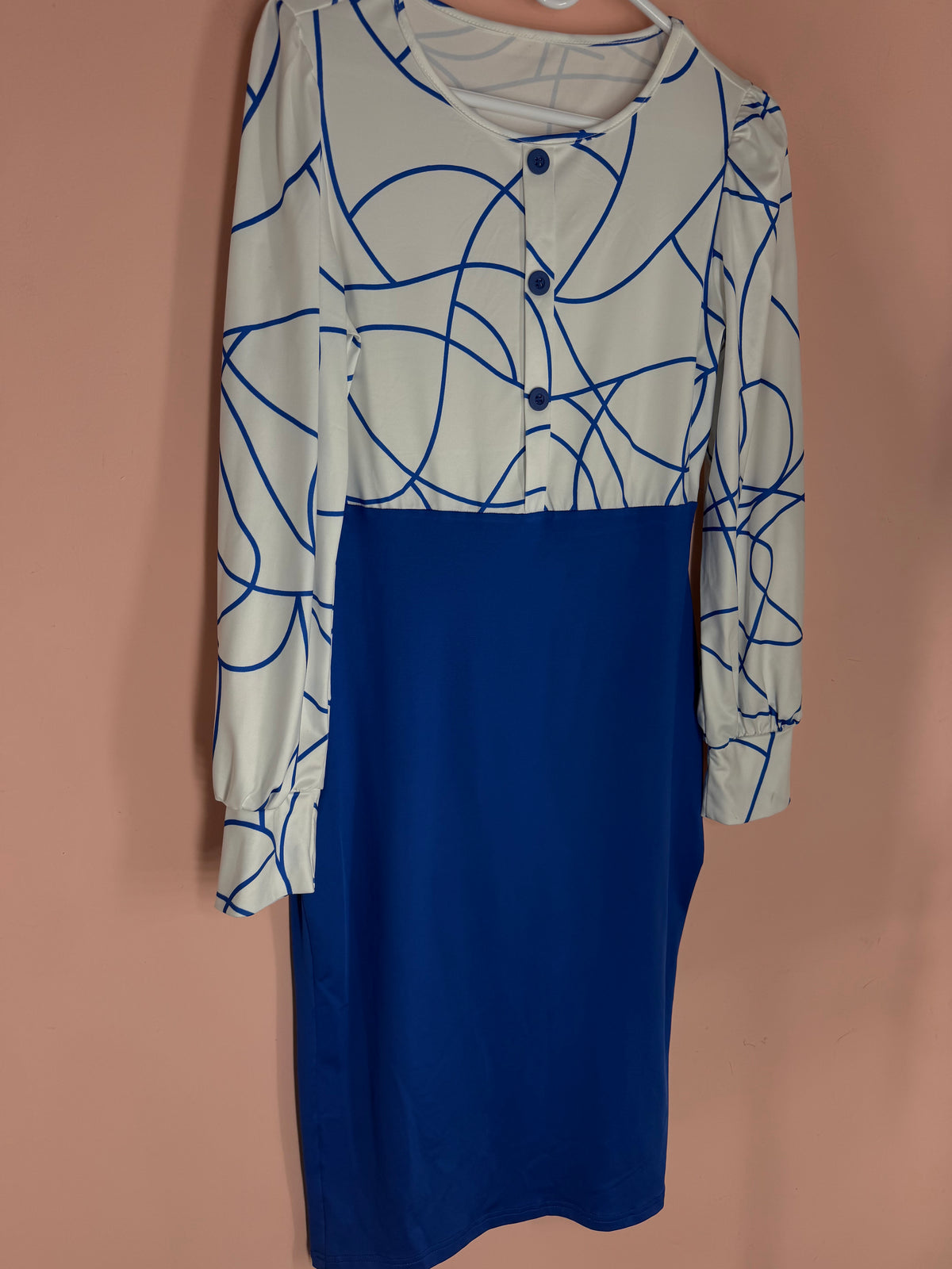 White bodice dress with royal blue abstract line print and solid royal blue skirt, long sleeves, front view