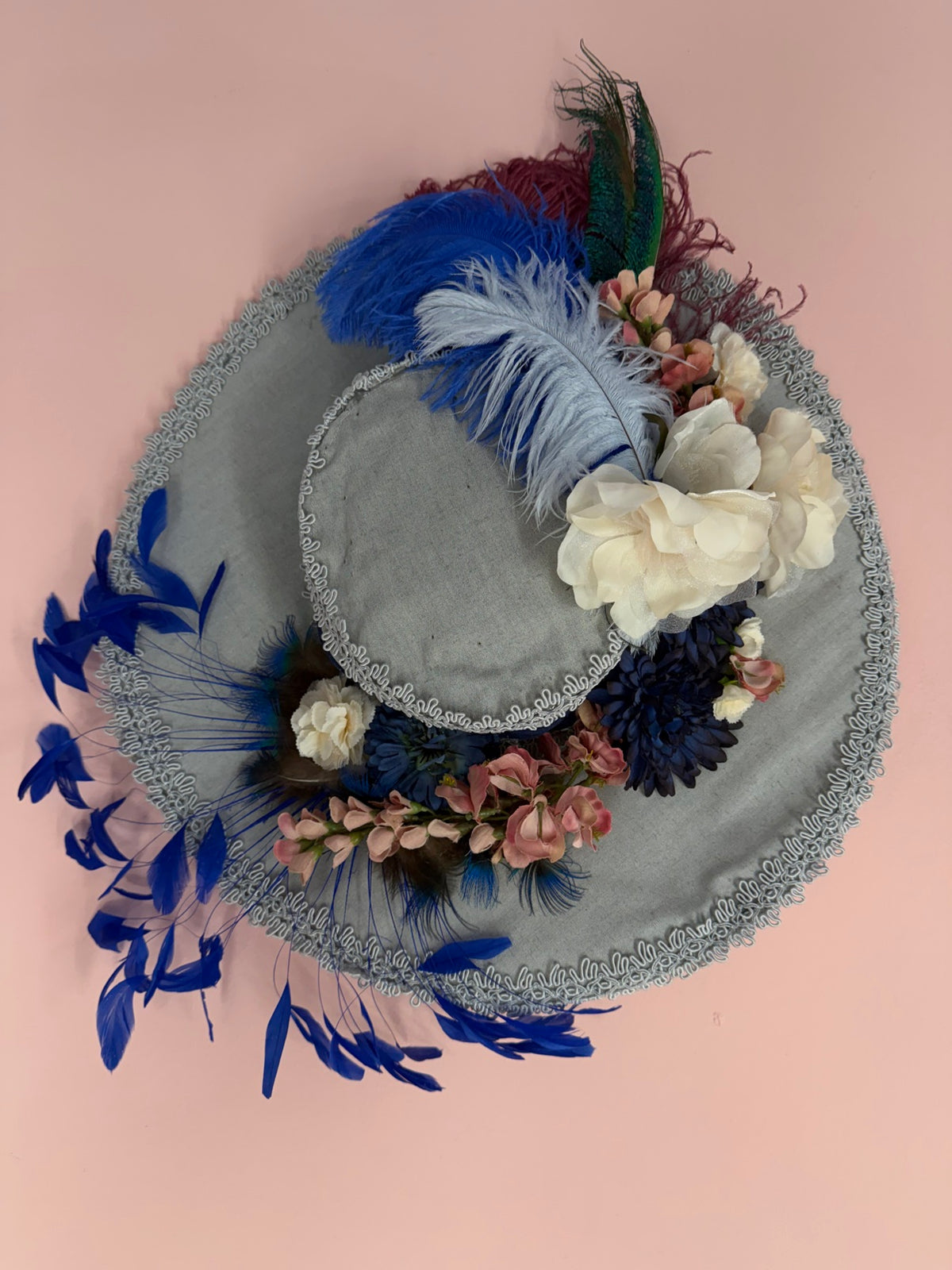 Vintage gray wide-brim statement hat designed and signed by Miss Crosby, with cream roses, navy silk flowers, royal-blue ostrich plumes and peacock feathers