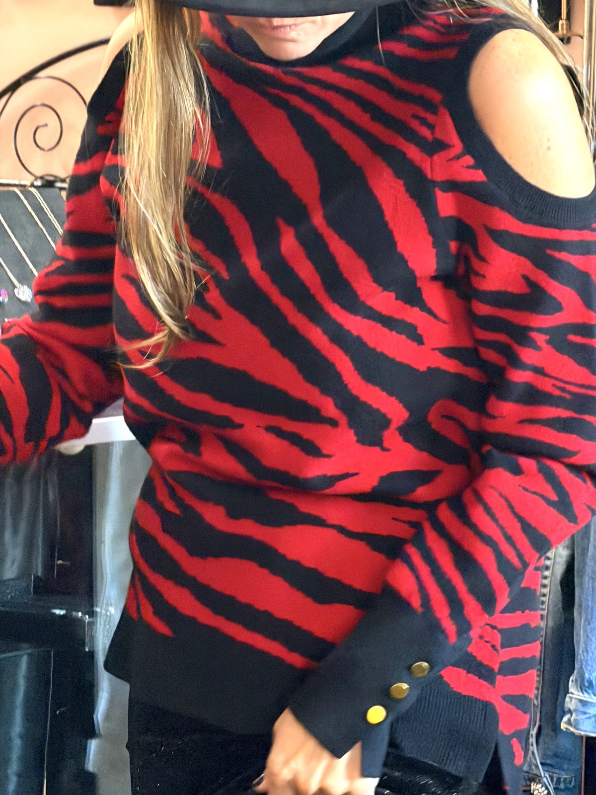 Red and black zebra cold-shoulder sweater worn, front close view