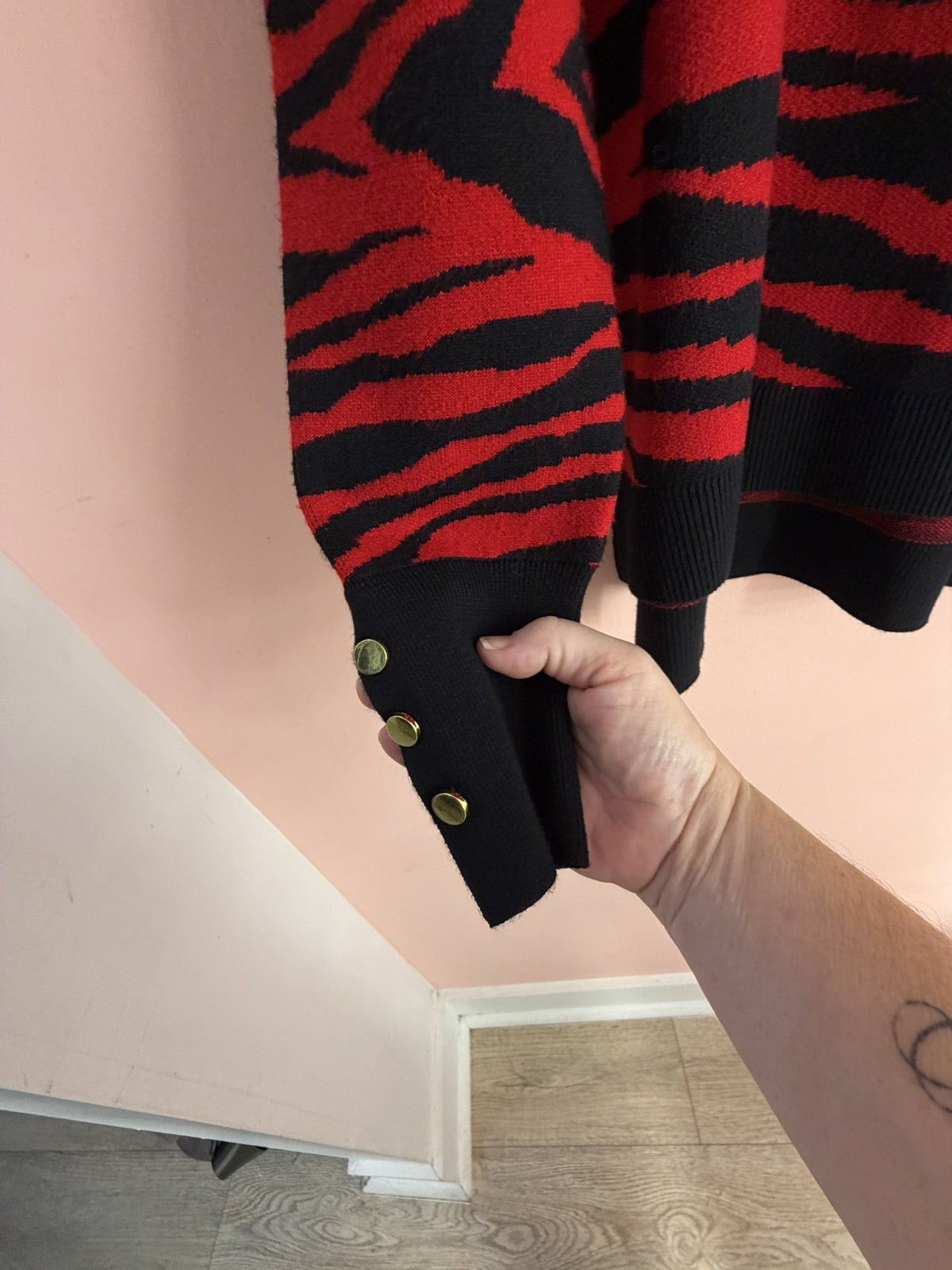 Red and black zebra sweater, gold-button cuff detail