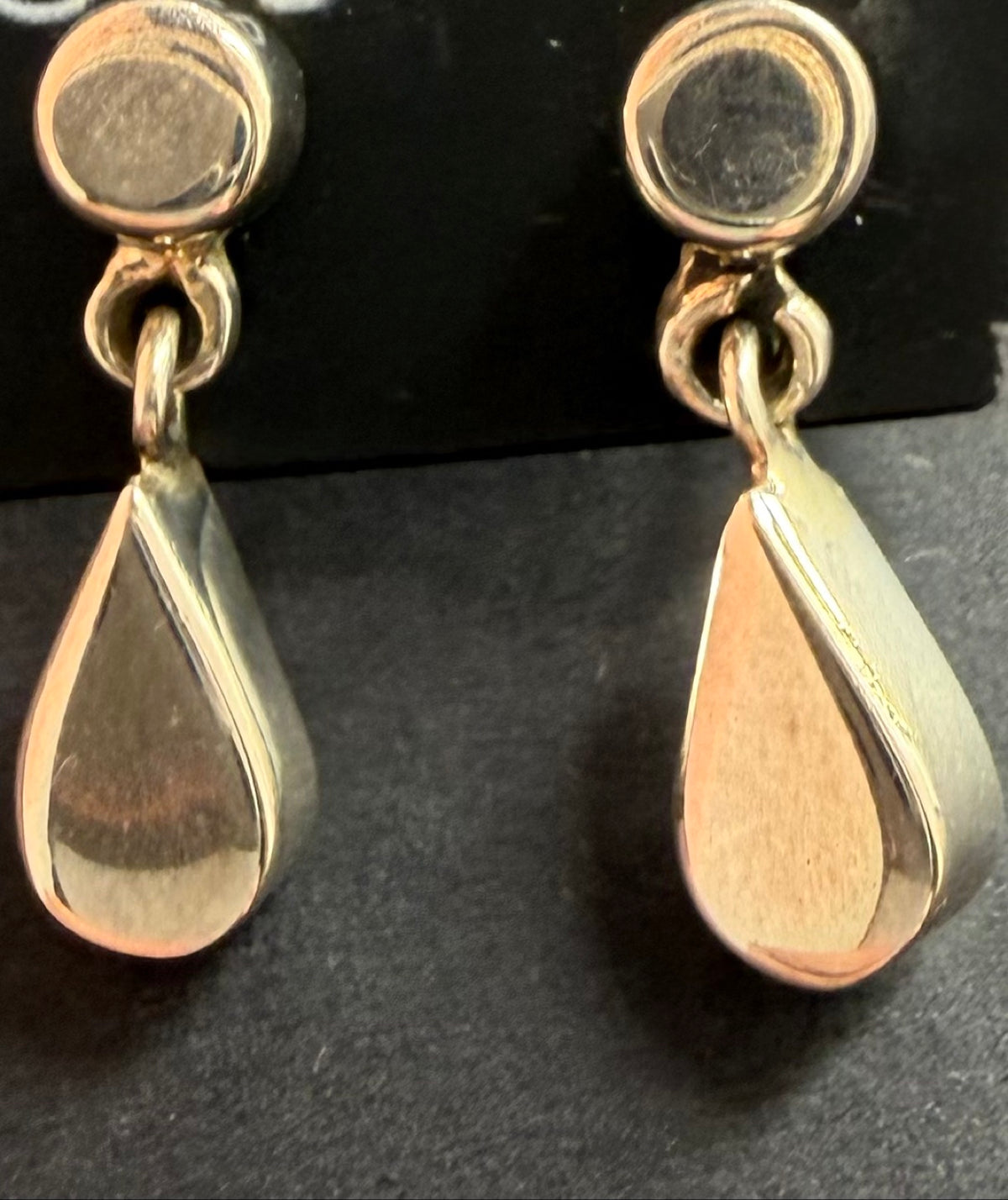 Sterling silver teardrop dangle earrings on black Regul Silver card, close-up