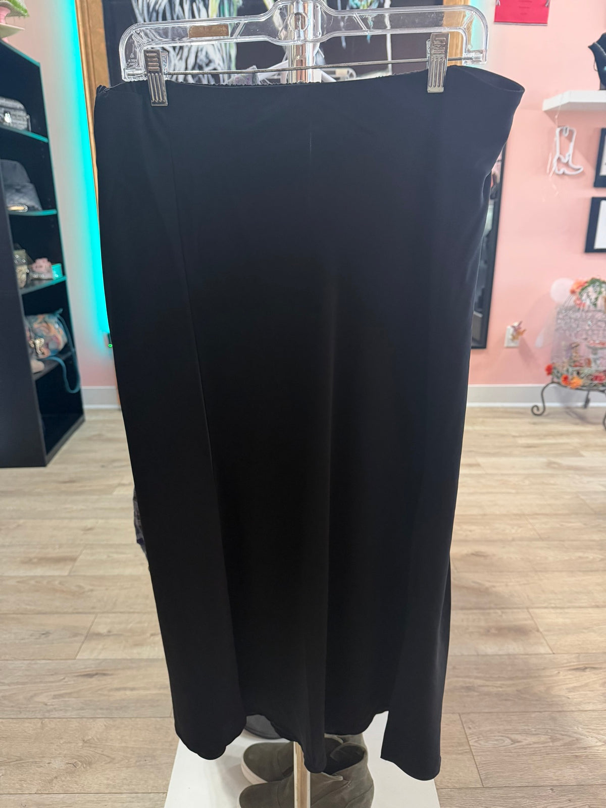 Front view of a like new black A-line column maxi skirt hanging on a boutique rack.