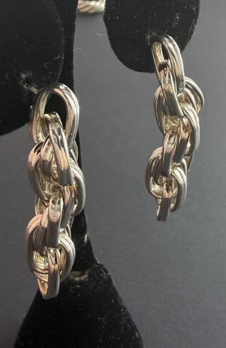 Polished chain-link dangle earrings on black display stand