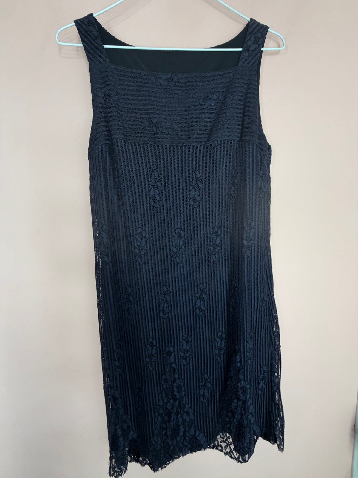 Black lace sleeveless dress on hanger, back view