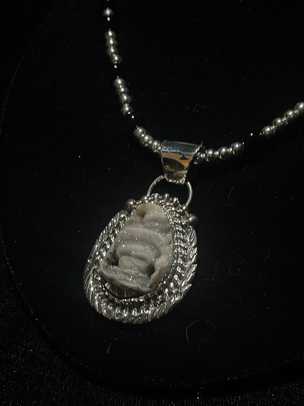 Desert Drusi pendant necklace - angled front view of the stone and wide bail on its obsidian beaded strand