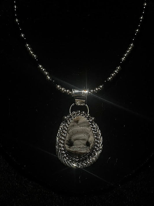 Desert Drusi pendant necklace - front view of the pale sparkling stone in its feathered sterling silver bezel