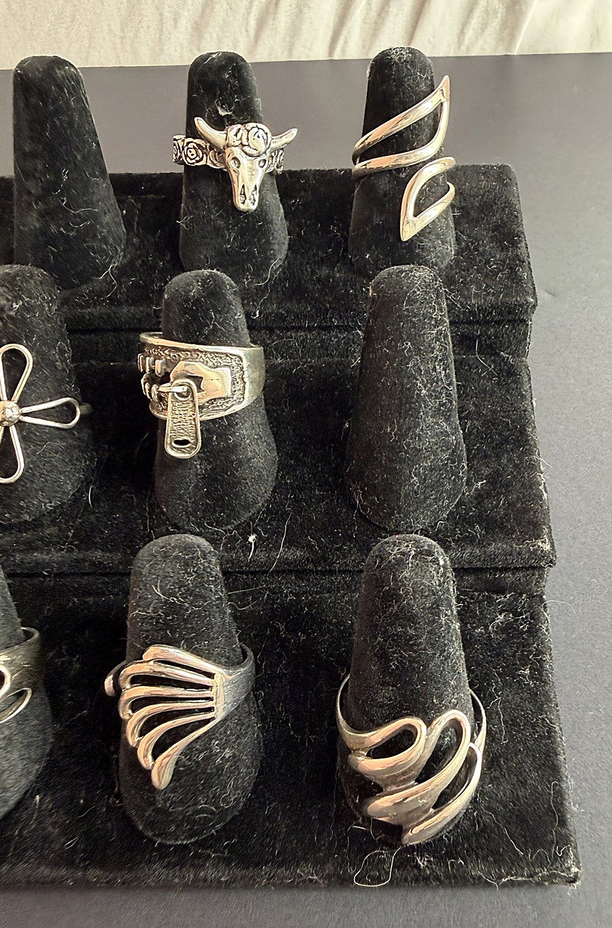 Sterling silver ring wholesale variety pack display showing longhorn skull, zipper, swirl, wing, cross and cutout band rings – Regul Silver