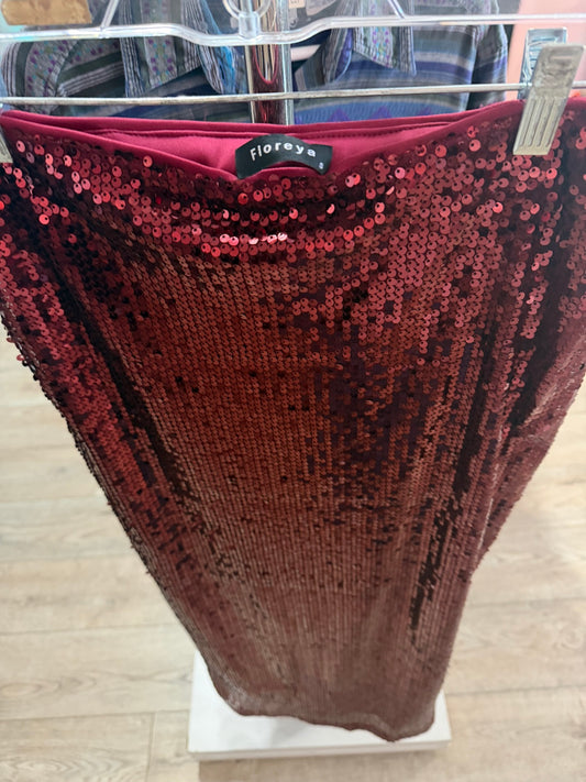 Close-up of overlapping dark red shimmering sequins on a luxury second-hand column skirt.