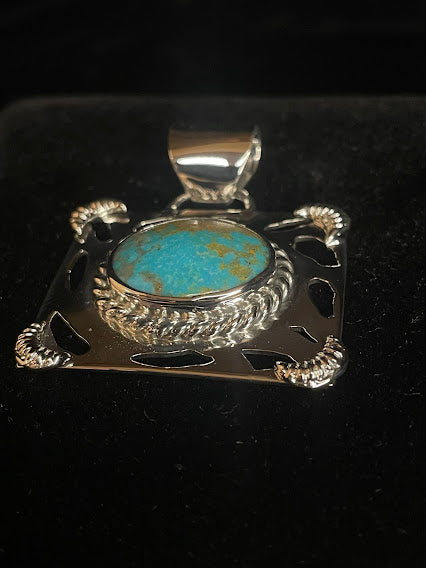 Genuine turquoise pendant - angled front view of the bright blue oval stone and its classic bail, stone face forward