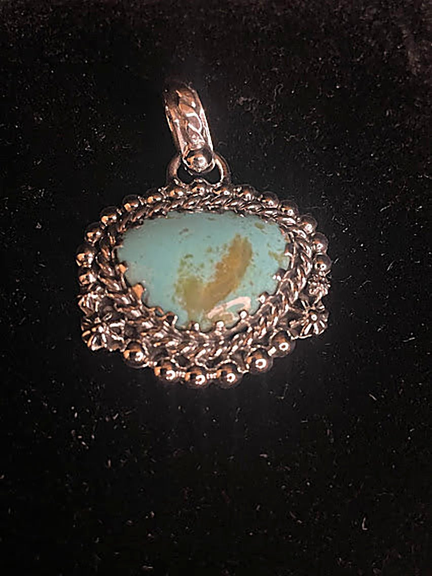 Genuine turquoise pendant - front view of the pale blue-green oval stone with its gold matrix heart in scalloped silver