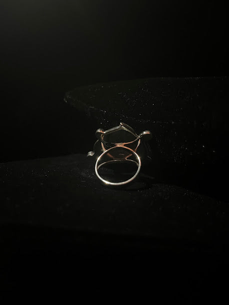 Labradorite teardrop ring — back view showing the split shank band and the frame from behind, on black