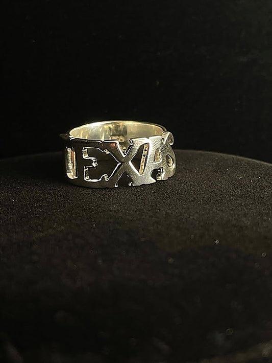 Mens sterling silver rings — Texas script ring with TEXAS cut through a wide sterling band, front view on black