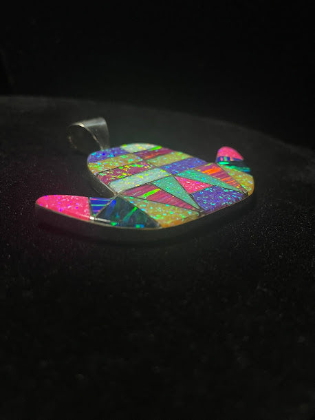 Opalite cowboy hat pendant — side view showing the inlay depth and silver edge, multicolor face, on black