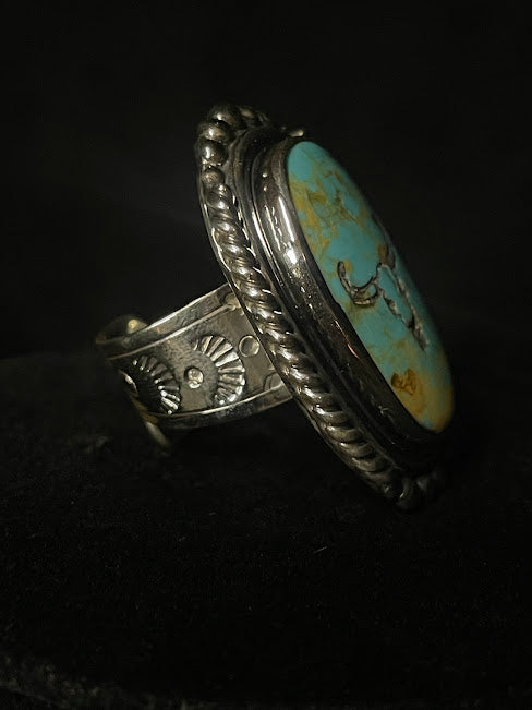 Oval turquoise ring — side detail of the rope bezel and the stamped sunburst worked into the band shoulder