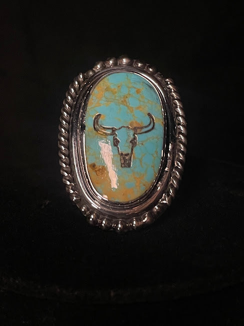 Oval turquoise ring — front view of the sky-blue Tyrone stone with the longhorn etched into it, rope-and-bead bezel