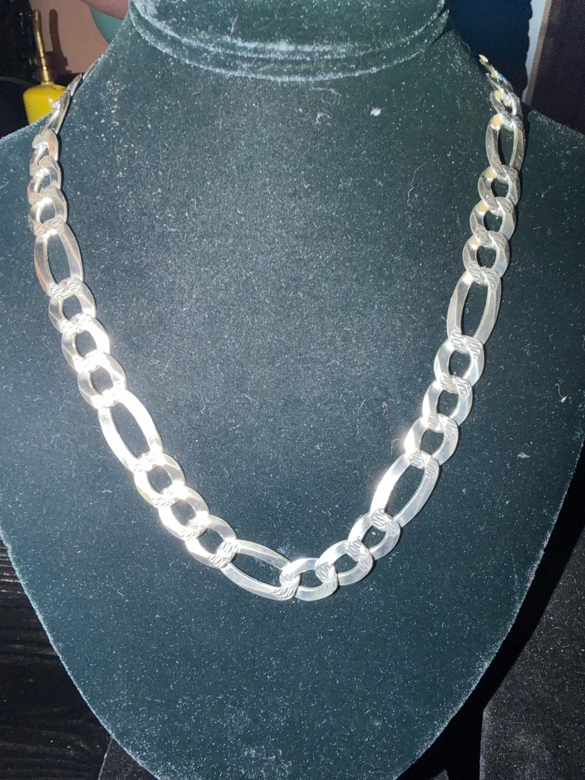 Figaro chain necklace with wide textured links in sterling silver on a black bust at Regul Silver