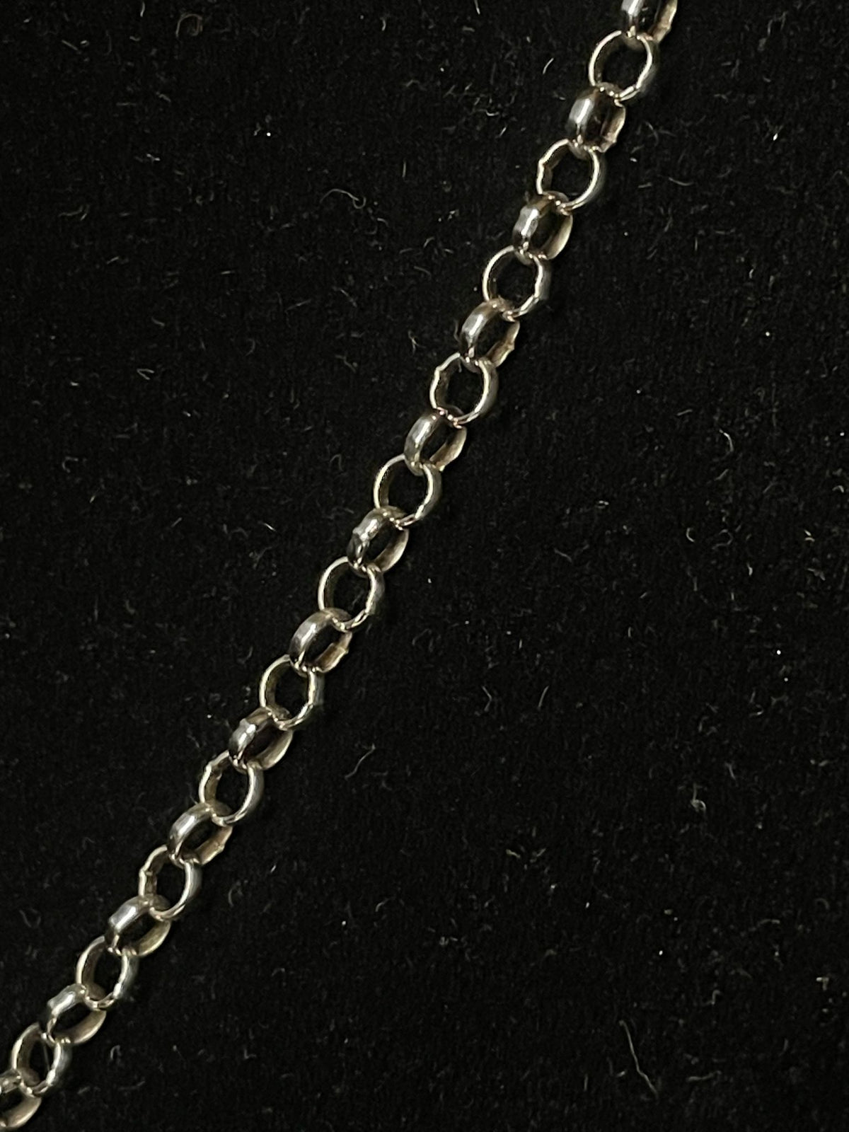 Sterling silver chain — close detail of the rolo chain’s round links on black