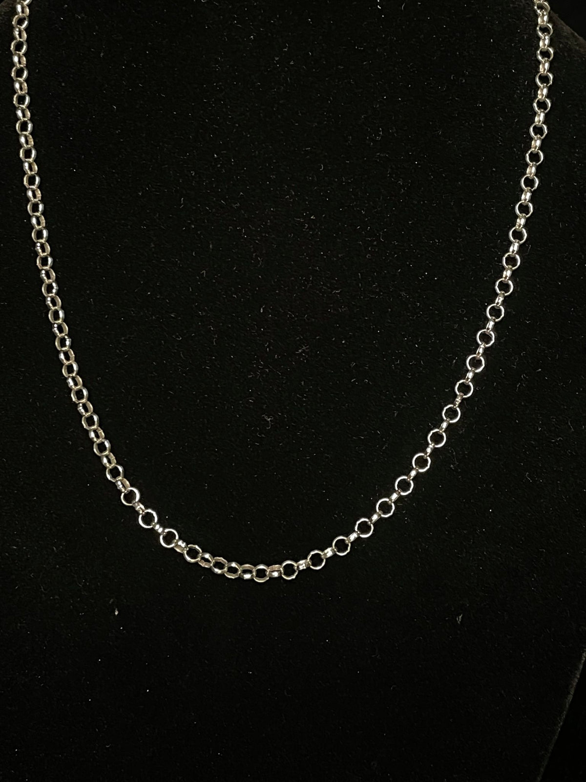Sterling silver chain — the rolo chain worn on a black bust, round links in an even rhythm