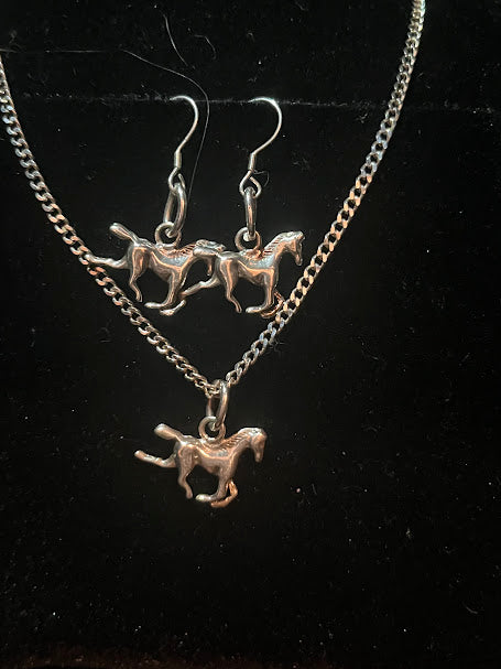 Sterling silver horse necklace in detail on black, with the matching horse earrings shown above the pendant