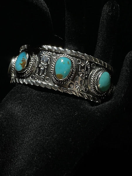 Turquoise cuff — three oval blue turquoise stones with brown matrix on a textured band, held on black
