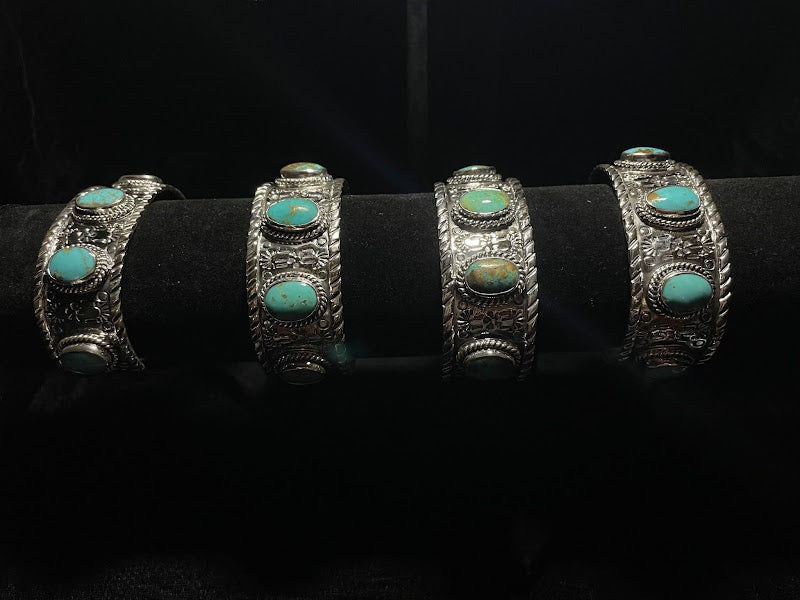 Turquoise cuff — four sterling silver cuffs with oval Sonoran turquoise stones on a black display bar