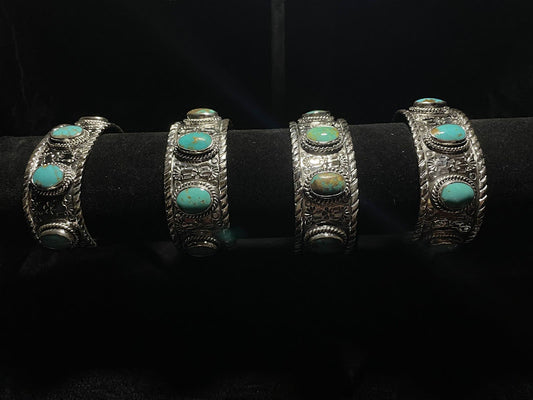 Turquoise cuff — four sterling silver cuffs with oval Sonoran turquoise stones on a black display bar