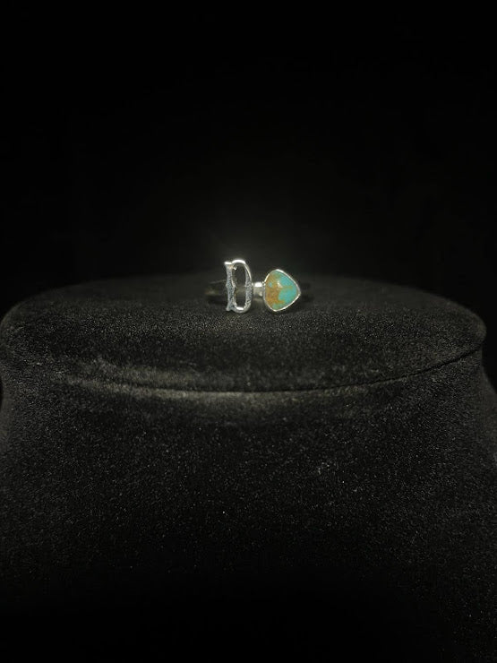 Turquoise initial ring — letter D in sterling silver beside a green teardrop stone, on black velvet