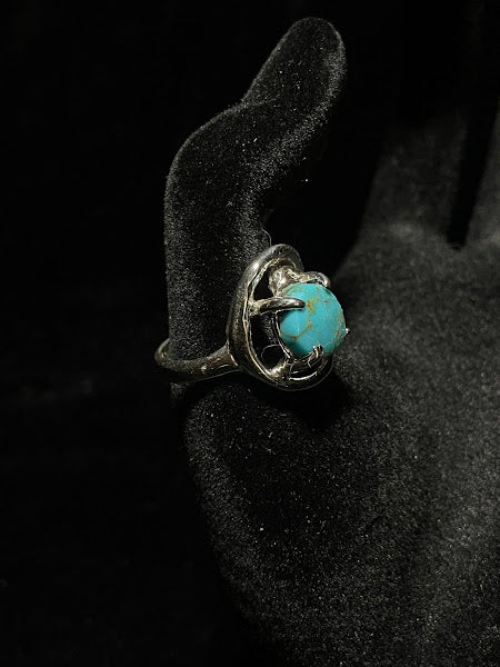 Turquoise ring — angled front view, round blue stone with golden matrix in prongs above the classic band