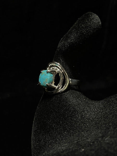 Turquoise ring — side view of the round Nacozari stone in prongs, artisan silver surround, on black velvet